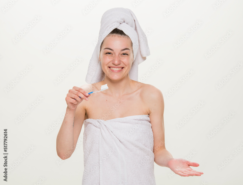 beauty portrait of a cheerful girl with a towel on her head isolated.Facial skin care and health concept.close-up on a white background. girl holding a glass holding an apple brushing her teeth making beauty portrait of a cheerful girl with a towel on her head isolated.Facial skin care and health concept.close-up on a white background. girl holding a glass holding an apple brushing her teeth making