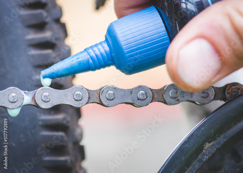 Valokuva Senior man hands spraying an oil to chain from the wheel bike, doing maintenance