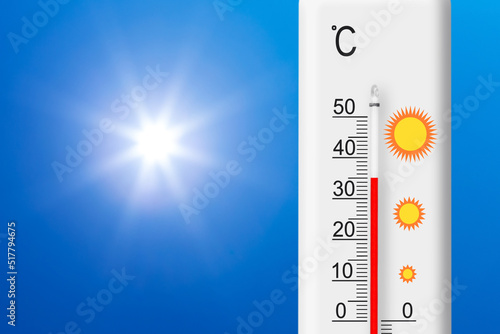 Celsius scale thermometer shows plus 35 degrees . Yellow sun in blue sky. Summer heat