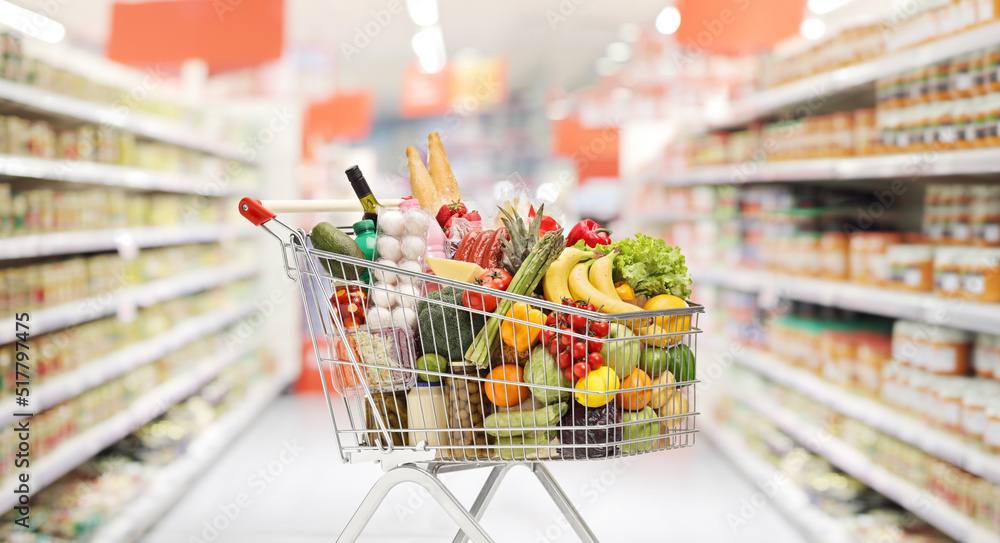 Full shopping cart with groceries in a supermarket Full shopping cart with groceries in a supermarket