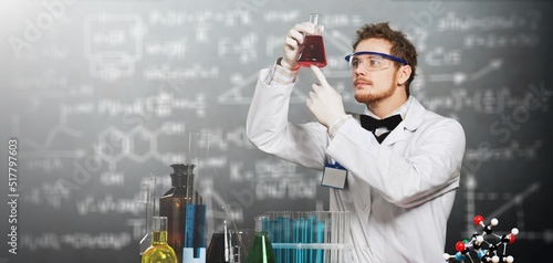 Obraz na plátne A young chemist conducting experiment mixing liquids in flask, laboratory assist
