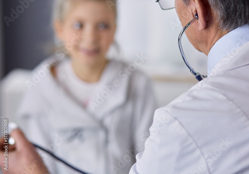 Girl and doctor with stethoscope listening to heartbeat