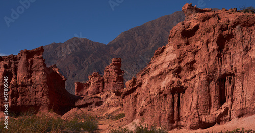 rock formation of reddish tones with mountains in the background of South America