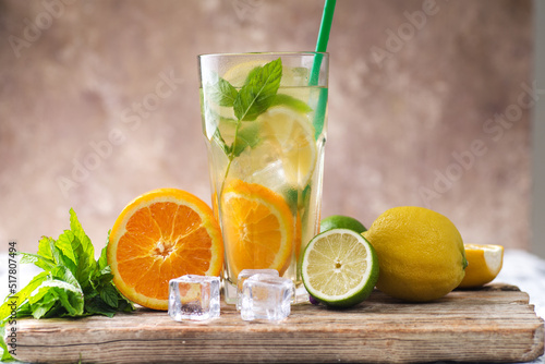 homemade lemonade or mojito cocktail with lime, mint and ice cubes in a glass