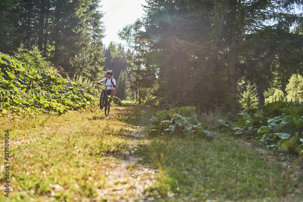 A cyclist rides a bike on extreme and dangerous forest roads. Selective focus