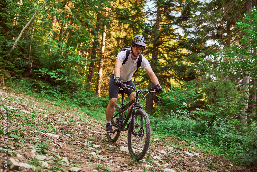 A cyclist rides a bike on extreme and dangerous forest roads. Selective focus