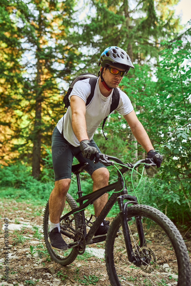 Fototapeta premium A cyclist rides a bike on extreme and dangerous forest roads. Selective focus