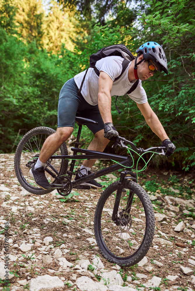 Obraz premium A cyclist rides a bike on extreme and dangerous forest roads. Selective focus