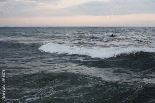 beautiful seascape storm on the sea cloudy sky in the water a surfer swims © Игорь Юркивский