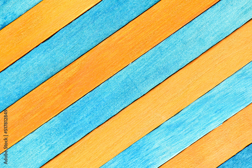 Fototapeta premium Alternating orange and blue diagonal wood panels. Two-tones wooden textured background. Wooden boards are painted blue and orange.