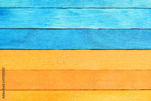 Bicolor background from blue and orange wooden planks. Wooden textured background with natural patterns. Orange and Blue painted wooden boards arranged horizontally.