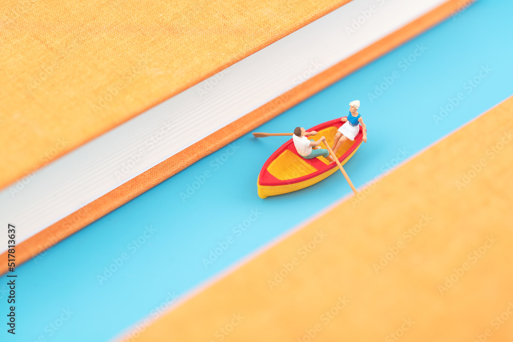 Miniature world cruise ship rowing among books