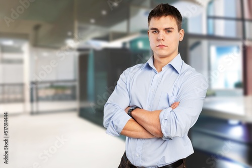 Successful Person. Portrait of confident smiling business man standing in modern coworking office hall, posing