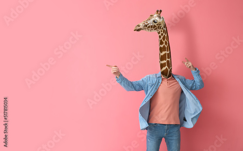 Man with head of giraffe on pink background