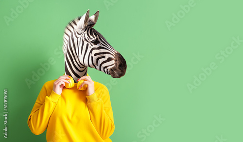 Woman with head of zebra and headphones on green background