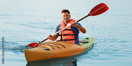 Young man kayaking in river...