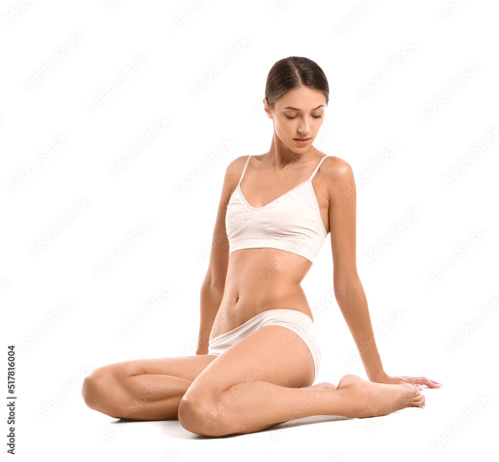 Young tanned woman in underwear sitting on white background Young tanned woman in underwear sitting on white background