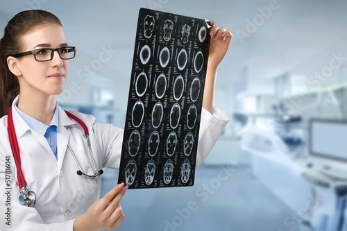 A surgeon doctor examining patient's x-ray films, scan in at radiology unit, hospital background. healthcare and medicine concept