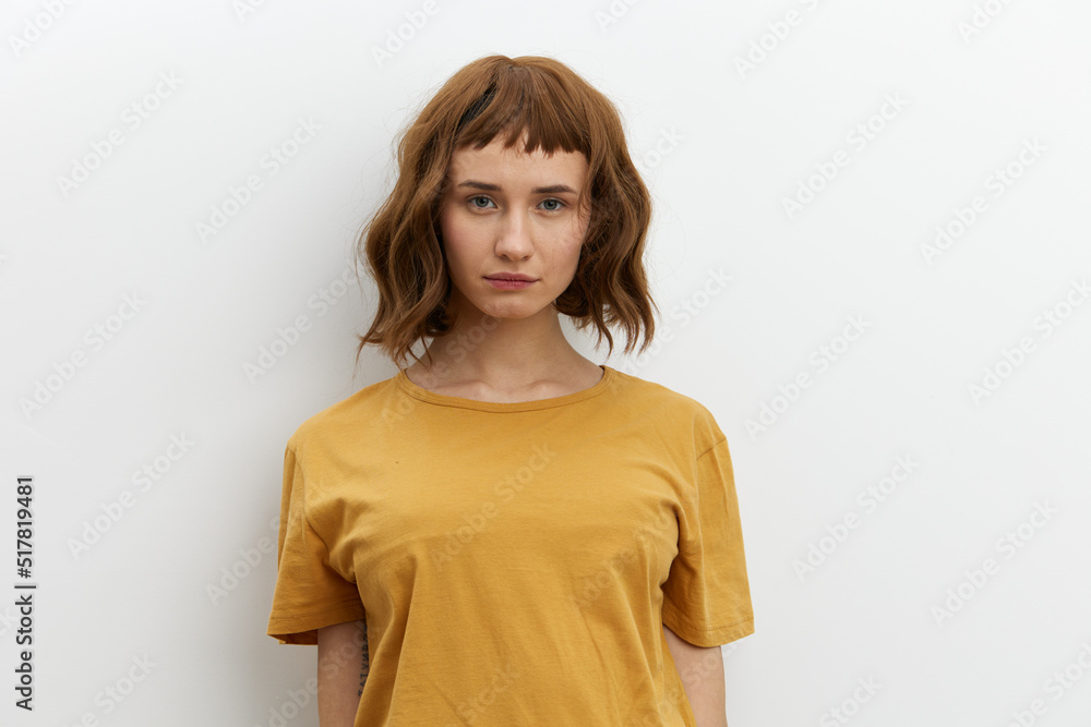a sweet, beautiful, romantic woman in a yellow T-shirt poses on a white background, smiling pleasantly looking at the camera. Horizontal photo with an empty space for inserting an advertising layout a sweet, beautiful, romantic woman in a yellow T-shirt poses on a white background, smiling pleasantly looking at the camera. Horizontal photo with an empty space for inserting an advertising layout