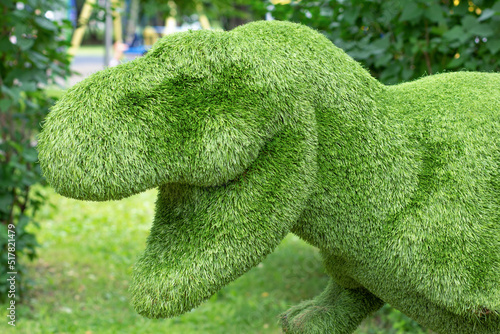 Decorative floral composition statue of dinosaur as artificial plant animal topiary for garden and park decoration photo