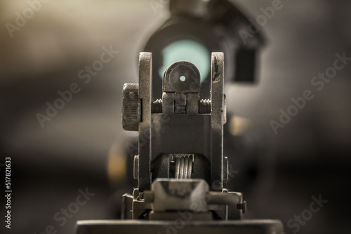 Close-up of flip rear sight and charging handle of assault rifle AR15 khaki camouflage