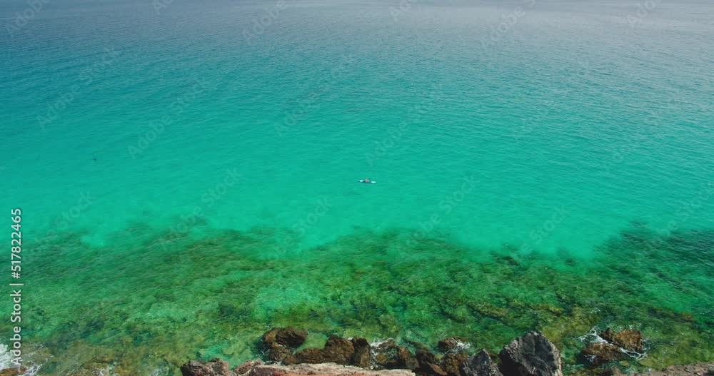 Treveler athlete swims in the ocean, rowing in sports kayak in tropical destination with turquoise transparent calm deep sea. Atlantic ocean waters on sunny day