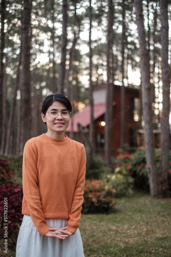 Happy woman in sweater traveling in pine tree forest, tourist visit at Doi Bo Luang, Chiang Mai, Thailand, Landmark and popular for tourist attractions. Vacation and journey concept Happy woman in sweater traveling in pine tree forest, tourist visit at Doi Bo Luang, Chiang Mai, Thailand, Landmark and popular for tourist attractions. Vacation and journey concept