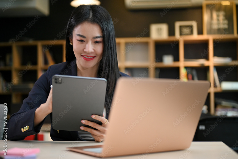 Businesswoman using portable digital tablet in the co-working space.