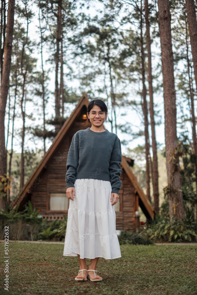 Happy woman in sweater traveling in pine tree forest, tourist visit at Doi Bo Luang, Chiang Mai, Thailand, Landmark and popular for tourist attractions. Vacation and journey concept Happy woman in sweater traveling in pine tree forest, tourist visit at Doi Bo Luang, Chiang Mai, Thailand, Landmark and popular for tourist attractions. Vacation and journey concept