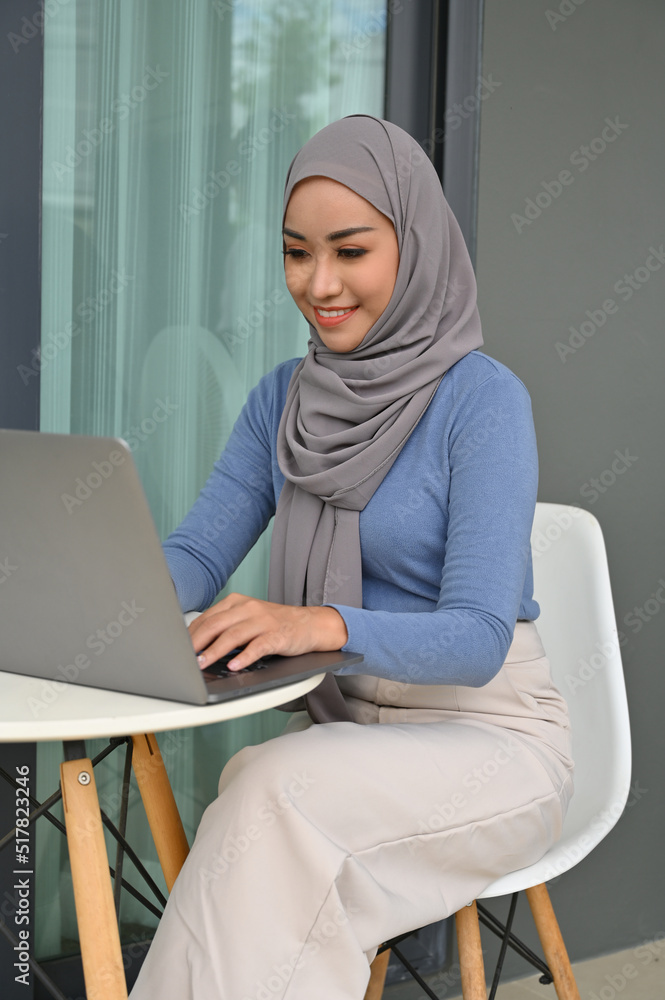 Asian Muslim woman wearing hijab using laptop computer. Asian Muslim woman wearing hijab using laptop computer.