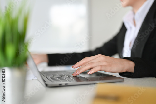 Close-up, A businesswoman using laptop computer, typing on keyboard