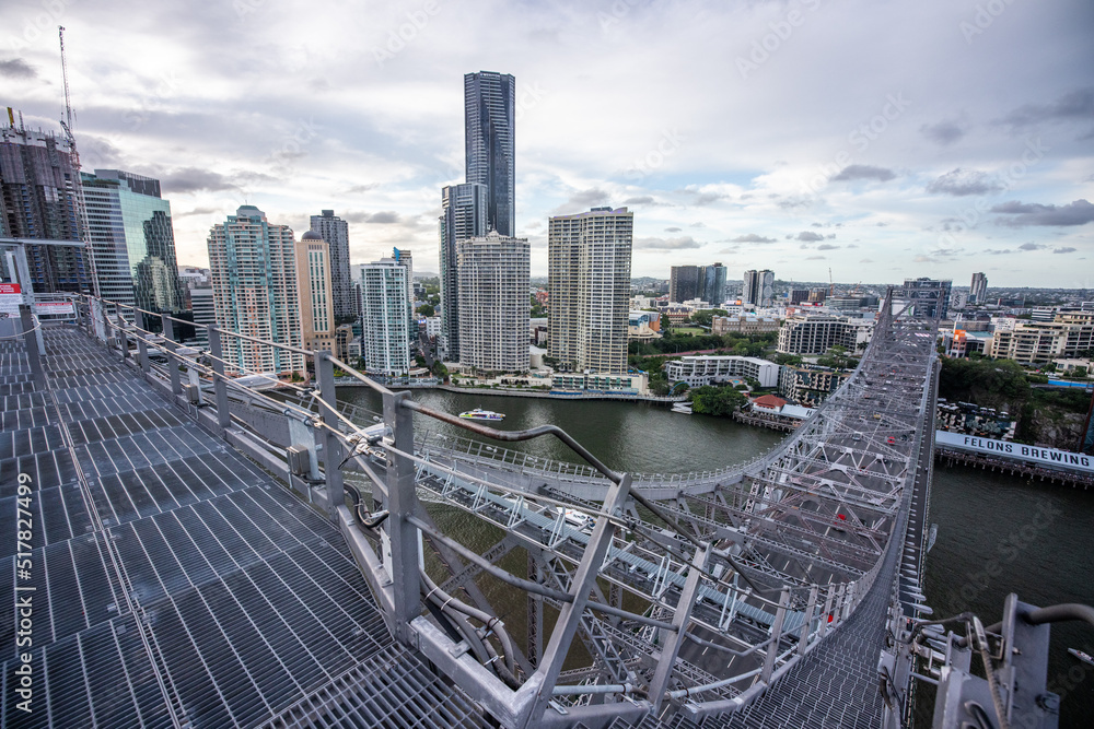 Obraz premium Modern city skyline and river seen from steel truss bridge walkway