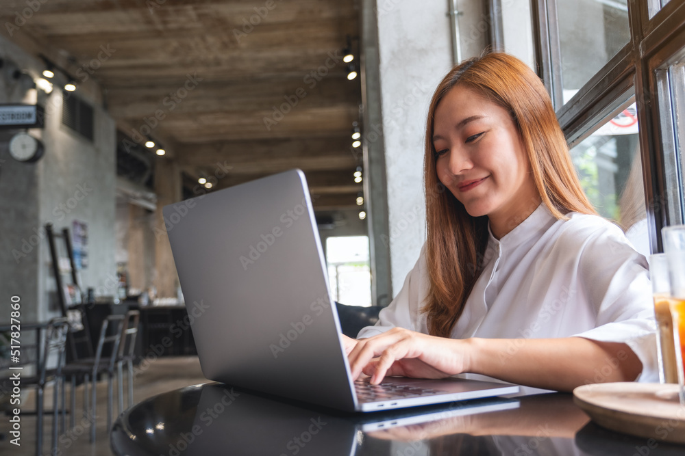 Portrait image of a businesswoman working and typing on laptop computer in cafe Portrait image of a businesswoman working and typing on laptop computer in cafe