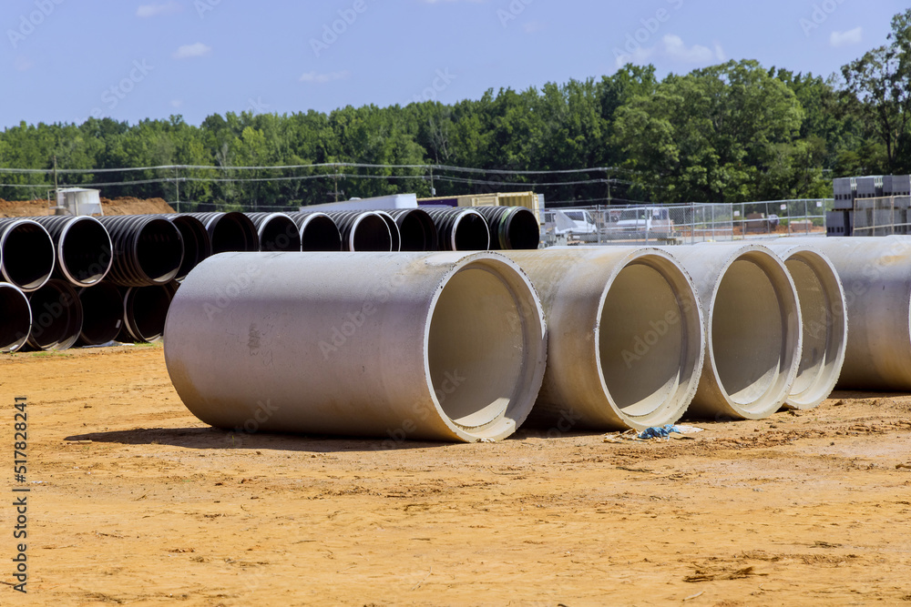 Stacked concrete pipes to construct drainage systems on building materials stack of construction Stacked concrete pipes to construct drainage systems on building materials stack of construction