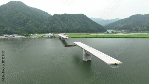 Rotate around bridge under construction and river by mountains photo