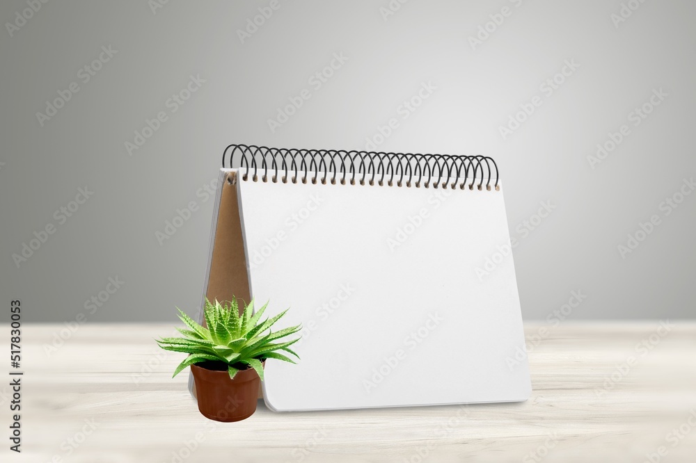 The 2022 desk calendar with plant on wooden table. The 2022 desk calendar with plant on wooden table.