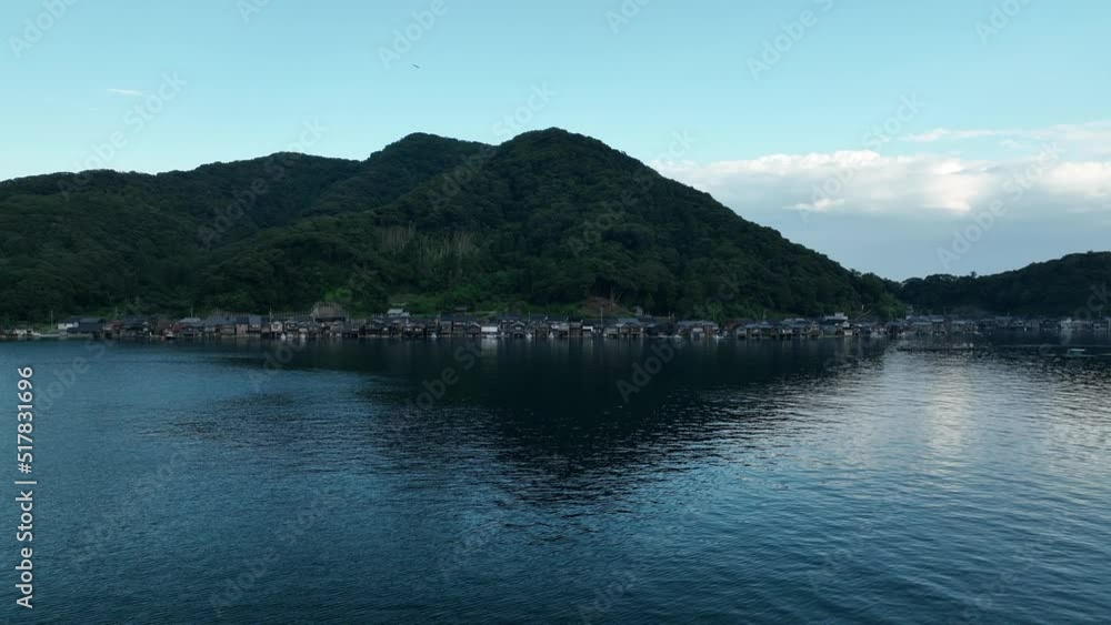 Slow move towards small fishing village at dusk with bird flyby Slow move towards small fishing village at dusk with bird flyby