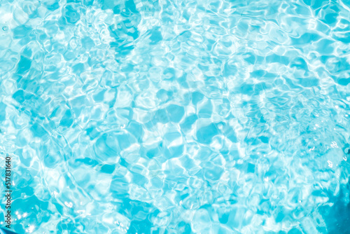 Blurred transparent blue colored clear calm water surface texture with splashes and bubbles. Trendy abstract nature background. Water waves in sunlight. water background © ISENGARD