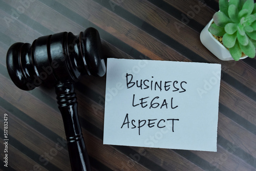 Concept of Business Legal Aspect write on sticky notes isolated on Wooden Table.