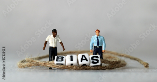 Business concept with white cube arranged in the word ’BIAS' and miniature people. The concept of racial prejudice. 