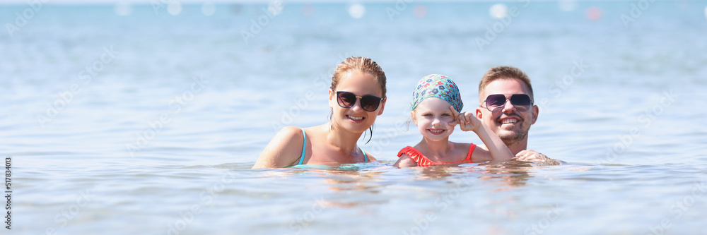 Happy family posing for picture together in sea or ocean Happy family posing for picture together in sea or ocean