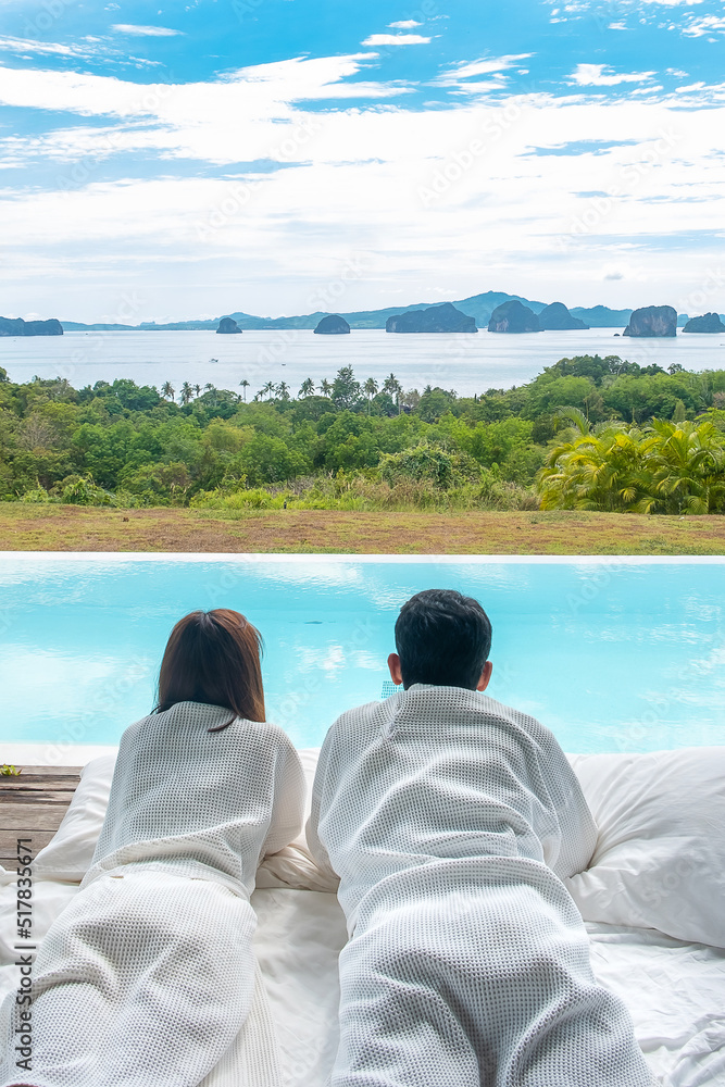 Happy Couple traveler enjoy Beautiful ocean view, Tourists relaxing in tropical luxury resort with swimming pool.Together, honeymoon, love, travel and summer vacation concept