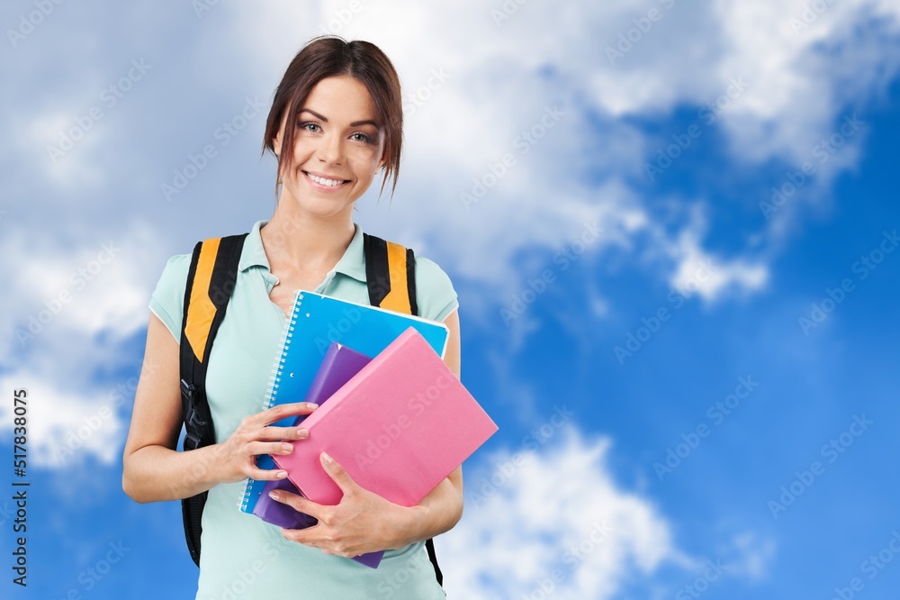 Young student woman wearing backpack and holding books Young student woman wearing backpack and holding books