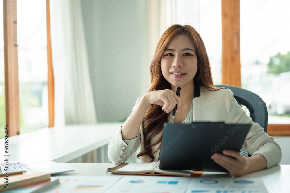 Charming Asian business woman have a happy of working laptop at the office. Looking at camera. Charming Asian business woman have a happy of working laptop at the office. Looking at camera.