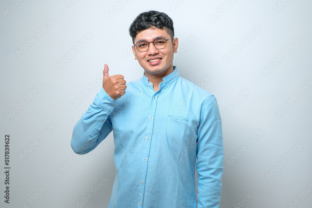 Young handsome man approving doing positive gesture with hand, thumbs up smiling and happy for success. Winner gesture. Young handsome man approving doing positive gesture with hand, thumbs up smiling and happy for success. Winner gesture.