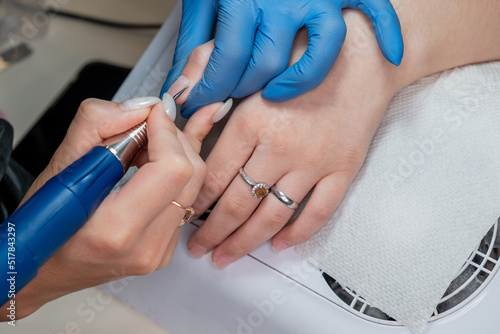 The manicurist cleans the nail with clean sterile tools. Careful work. Beauty saloon.