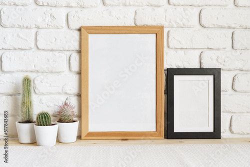 Square wooden photo frame and cactus plants on the table © fotofabrika