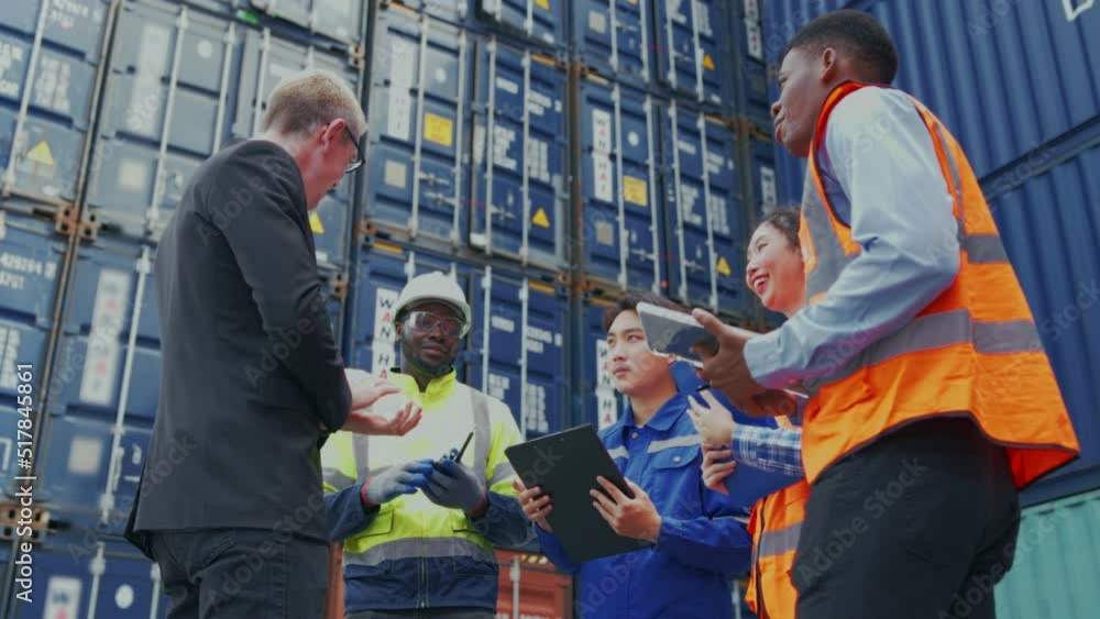 Low level angle of business man and Industrial shipping worker discuss together at container yard.