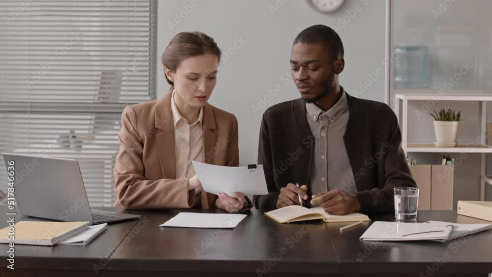 POV medium slowmo of team of professional multiethnic hr managers looking through applicant cv and speaking at camera, having job interview in office POV medium slowmo of team of professional multiethnic hr managers looking through applicant cv and speaking at camera, having job interview in office