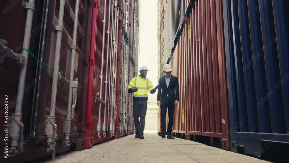 Low level angle Foreman and inspector checking container box for quality control of logistic export and import in docker. Low level angle Foreman and inspector checking container box for quality control of logistic export and import in docker.
